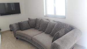 a couch with pillows on it in a living room at Apartman BARAKA in Šibenik