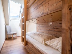 Łóżko piętrowe w pokoju z drewnianą ścianą w obiekcie Charming Apartment in Gosau with shared Sauna w mieście Gosau