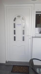 Una puerta blanca con una ventana en una habitación en Apartman BARAKA en Šibenik