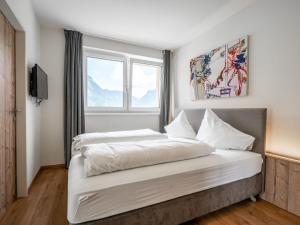 1 dormitorio con 1 cama blanca grande y ventana en Peaceful Apartment in Gosau with shared Sauna, en Gosau