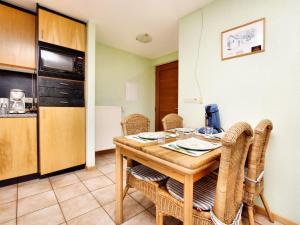 cocina y comedor con mesa de madera y sillas en Comfortable Holiday Home in St Vith, en Amelscheid