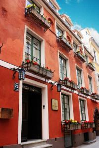 ein rotes Gebäude mit Blumenkästen und Fenstern in der Unterkunft St. Peter's Boutique Hotel in Riga