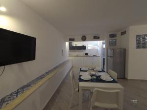 un soggiorno con tavolo e TV a parete di la petit maison a Palermo