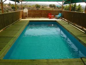 a swimming pool with a deck and a table and chairs at tranquil beautiful house כליל השחר- צימרים קסומים במיקום מרגיע למשפחות וזוגות in Clil