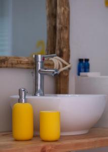 a bathroom with a sink and two yellow cups at Casa di Greco in Vourvourou