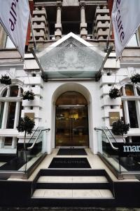 een ingang van een gebouw met twee vlaggen ervoor bij Mercure London Bloomsbury Hotel in Londen