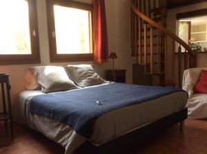 a bedroom with a bed with a blue blanket on it at Chambres d'Hotes Au Val Dormant in Réalville