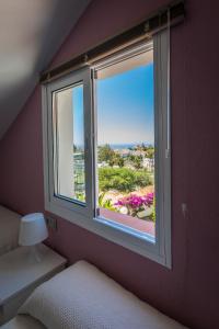 a bedroom with a window with a view at Apartamentos Las Rosas de Capistrano in Nerja