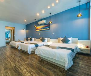 a room with four beds and a blue wall at Sara Resort in Koh Rong Sanloem
