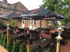 a restaurant with tables and chairs and an umbrella at Hotel Mylos in Sittensen