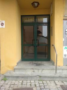 una puerta verde en un edificio amarillo con escalones en Apartamentos turísticos Vistademar, en Luarca
