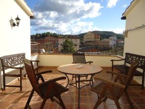 patio con mesa y sillas en el balcón en Hostal Casa Laure y Mª Jose, en Arens de Lledó