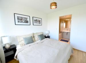 ein Schlafzimmer mit einem weißen Bett und zwei Bildern an der Wand in der Unterkunft Erdberger Lände in Wien