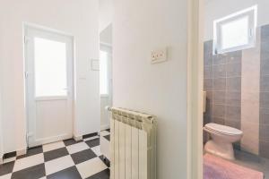 a bathroom with a toilet and a checkered floor at Cozy new flat for 2 or 3 in Hvar