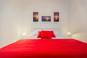 a bedroom with a red bed with two red pillows at Cozy new flat for 2 or 3 in Hvar