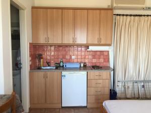 a kitchen with wooden cabinets and a white refrigerator at Eugenia travasarou sea view appartments in Diakofti