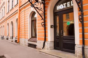 a building with a black door on a street at Yellow Hotel in Saint Petersburg
