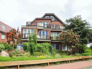 ein großes Backsteingebäude mit Balkonen auf einer Straße in der Unterkunft Duhner Strandliebe in Cuxhaven