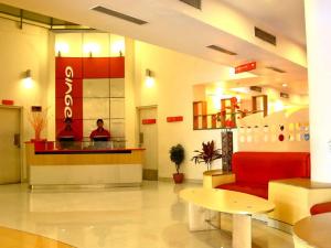 a lobby of a hotel with a red couch and a counter at Ginger Guwahati in Guwahati