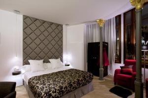 a bedroom with a large bed and a red chair at Anba Boutique in Barcelona