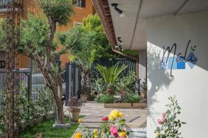 um pátio com vasos de plantas e uma cerca em Malì Trevignano Piccolo Hotel em Trevignano Romano