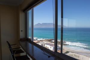 a room with a large window with a view of the ocean at Breathtaking views in Blouberg! in Bloubergstrand