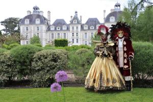 a couple in costumes standing in front of a building at roulotte du domaine des Chevrettes in Cour-Cheverny
