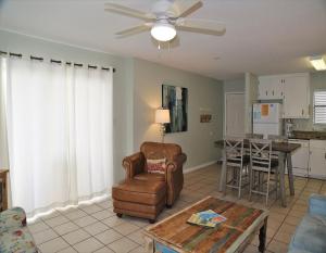 ein Wohnzimmer mit einem Stuhl und einem Tisch in der Unterkunft Southern Sands 104 Condo in Gulf Shores