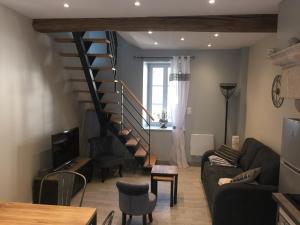 - un salon avec un escalier, un canapé et une table dans l'établissement Gite le murger, à Meursault