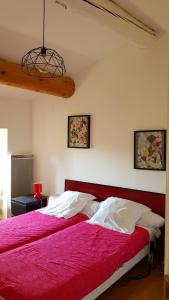 Gite Le Moulin de Rosieres Moulin Champetier في Rosières: غرفة نوم بها سرير كبير وبطانية حمراء