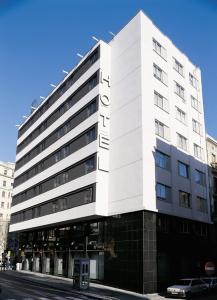 ein großes weißes Gebäude in einer Stadtstraße in der Unterkunft Hg City Suites Barcelona Apartments in Barcelona