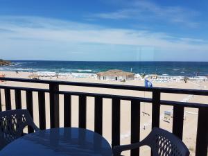 a table and chairs on a balcony overlooking the beach at Oasis Del Sol - Front Beach in Lozenets