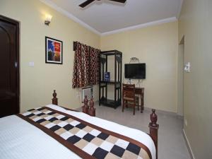 Dormitorio con cama con colcha estampada de tablero de ajedrez en Hotel Ajit Mansion, en Jodhpur