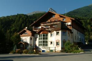 un grande edificio bianco con un tetto di legno di Sporthotel Mölltal a Flattach