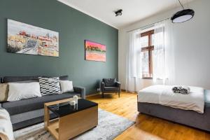 een woonkamer met een bank en een bed bij Bridge Apartments 6 in Krakau