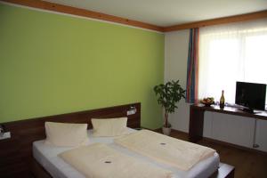 a bedroom with two beds and a green wall at Sporthotel Mölltal in Flattach