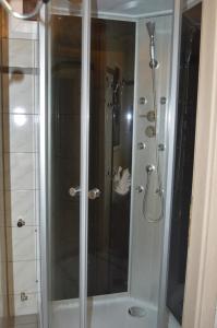 La salle de bains est pourvue d'une douche avec une porte en verre. dans l'établissement Hotel Zur Rose, à Bad Karlshafen