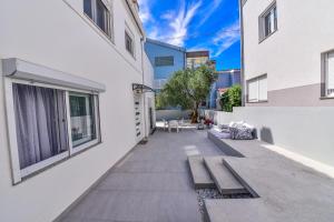 un patio con un banco en el lateral de un edificio en Villa Benelux, en Zadar