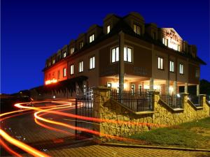 un edificio con senderos ligeros delante de él por la noche en Hotel Zawiercie en Zawiercie