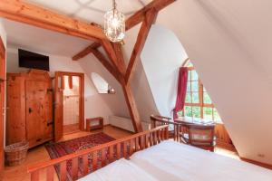 an attic bedroom with a bed and a table at Die Insel auf Rügen in Rambin