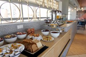 a buffet line with different types of bread and pastries at Evripides Hotel in Athens