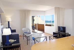 een woonkamer met een kamer met een tafel en stoelen bij Apartaments Beach & Golf Resort in Pals