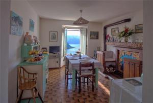 eine Küche und ein Esszimmer mit einem Tisch und Stühlen in der Unterkunft Holiday Home Liliana in Faggeto Lario 