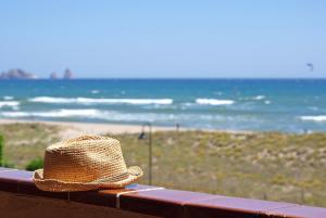 a straw hat sitting on a fence near the beach at Apartaments Beach & Golf Resort in Pals