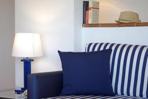 a blue and white couch sitting next to a lamp at Apartaments Beach & Golf Resort in Pals