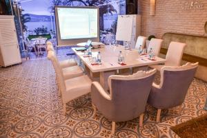 a conference room with a table and chairs and a screen at Büyükada Port Hotel in Buyukada