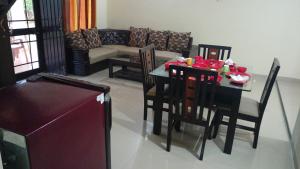 a living room with a table and chairs and a couch at Aakriti NS71 in Bhopal