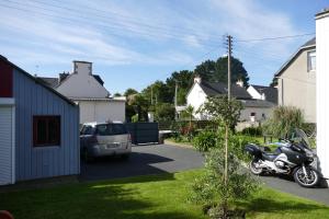 una motocicleta estacionada en la entrada de una casa en Chambres d'hotes chez laure & François en Paimpol