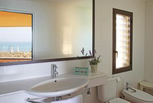 a bathroom with a sink and a toilet and a mirror at Apartaments Beach & Golf Resort in Pals