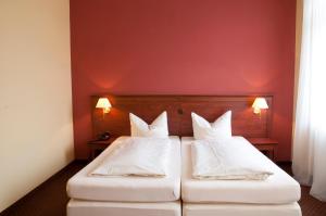 a hotel room with two beds and two lamps at City Hotel garni in Idar-Oberstein